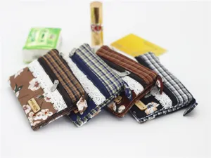 Close-up detail view of multi-layer fabric coin purses featuring floral patterns and lace trim.