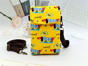 Detailed view of the yellow canvas crossbody phone bag featuring cute dachshund dog print.