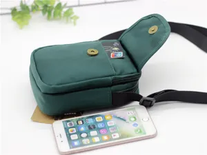 Vista ravvicinata della piccola borsa a tracolla per cellulare in nylon verde scuro con tasche.