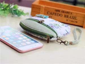 Floral print canvas coin purse with double zipper and wrist strap, compact and portable design.