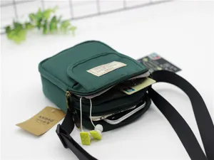 Vista dettagliata della borsa a tracolla per cellulare in nylon verde scuro con tasca e etichetta.