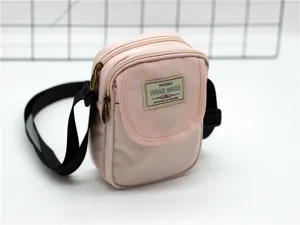 Vista dettagliata della borsa a tracolla rosa in nylon per cellulare con zip e tracolla nera.