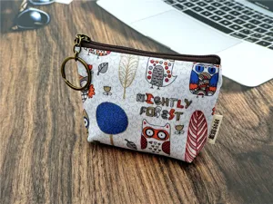 Gedetailleerd weergave van canvas portemonnee met uilenmotief en sleutelhanger.