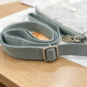 Canvas crossbody phone bag with leaf pattern, adjustable strap and metal buckle for women.