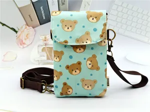 Detailed view of the cute brown bear print phone bag, showing waterproof fabric and metal hardware.