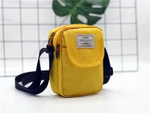 Vista dettagliata della borsa a tracolla per telefono in nylon giallo con cinturino scuro.
