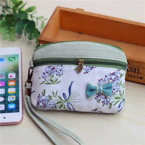 Floral fabric coin purse with wrist strap and dual zipper closure for women and girls.