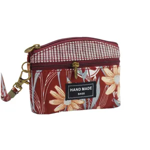 Floral fabric coin purse with double zippers and wrist strap for daily use and travel.
