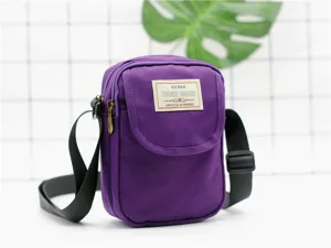 Borsa a tracolla in nylon viola per cellulare con cinghia regolabile e dettaglio etichetta.