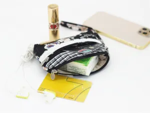 Detail view of mini floral coin purse showcasing internal capacity and multi-function storage.