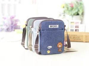 Piccola borsa a tracolla in tela denim con ricamo di orsetto, cinghia regolabile e zip.