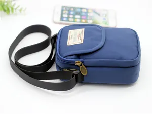 Vista dettagliata della borsa a tracolla in nylon blu per telefono con cinturino e etichetta.