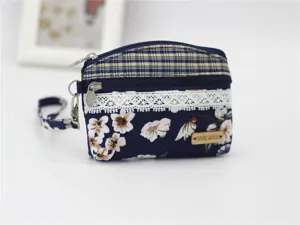 Compact floral fabric coin purse with plaid trim, lace detail, dual zippers and strap.