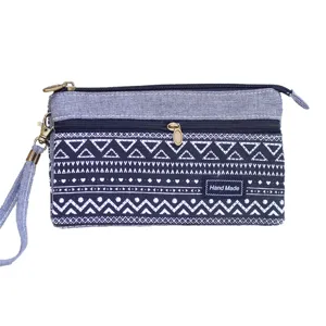 Canvas clutch tas met geometrische witte print, handige ritssluiting en polsband.
