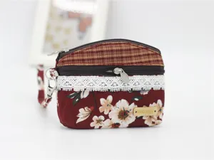 Cute floral fabric coin purse with double zippers, lace trim and handy wrist strap for women.