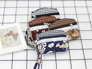 Detail view of Korean style floral plaid fabric coin purses with lace trim and double zippers.