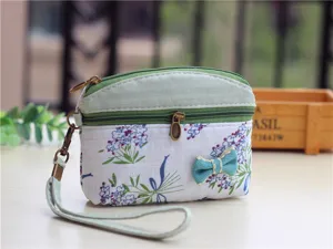 Fabric coin purse detail, cute floral print, double zipper, convenient wrist strap design.