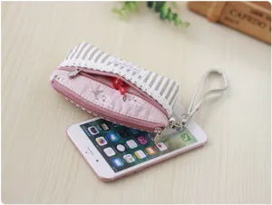 Detailed view of the striped floral fabric coin purse with double zippers and handy wrist strap.