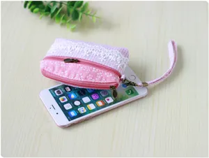 Detailed close-up view of the pink floral plaid coin purse featuring lace trim and a wrist strap.