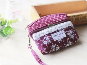 Floral fabric coin purse with lace trim, double zipper, and wrist strap for women.