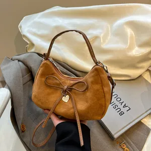 Bruine suède schoudertas met chique strik en hartvormige hanger, elegante crossbody.