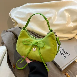 Heldere groene schoudertas met strik en hartjes hanger, elegante forenzenstijl voor dames.