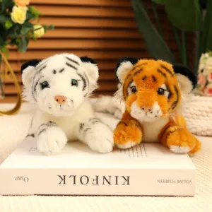 Close-up of cute simulation plush tiger toys in prone posture, soft fabric and detailed design.