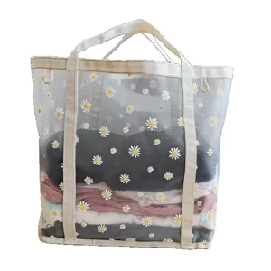 Vista detallada de la bolsa de malla transparente con estampado de margaritas y asas resistentes.