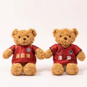 Cute football teddy bear plush toy wearing red jersey, custom fan gift doll with logo details.