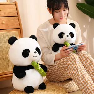 Cute panda plush toy detail showing soft fabric and bamboo leaf prop in cozy indoor setup.