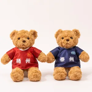 Detailed view of cute teddy bear plush toys wearing football jerseys with city text prints.