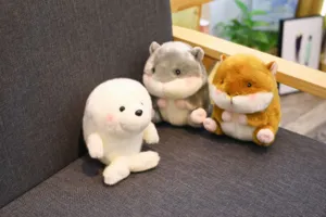 Detail view of cute round plush toys, including a white seal and fluffy hamsters for kids.