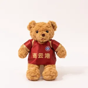 Plush teddy bear doll wearing a red football jersey with custom team logo and text detail.