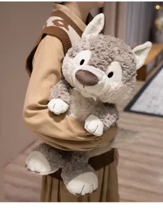 Close-up detail of the soft plush wolf toy held in hands, showcasing fluffy grey fur texture.