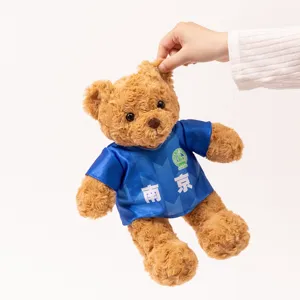 Close-up detail of a cute brown teddy bear plush toy wearing a blue football jersey.