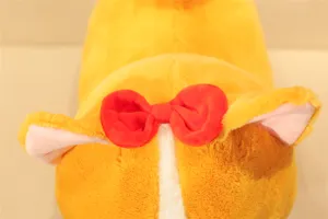 Close-up detail of cute yellow corgi plush toy with red bow soft and fluffy fabric design