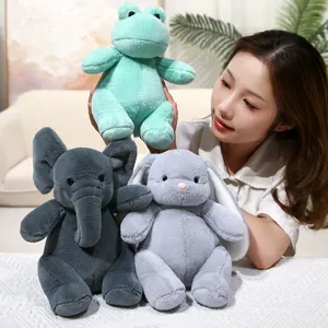 Adorables peluches de rana, elefante y conejo en un acogedor escenario. Suaves y tiernos.