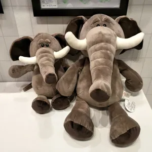 Detailed view of cute plush elephant toys set in a cozy store display, soft grey fabric.