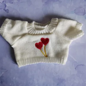 Cute white knitted doll sweater with red heart embroidery, perfect doll clothing accessory.