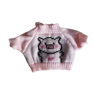 Cute pink knitted doll sweater featuring cute cartoon pig design for plush toy dress up.