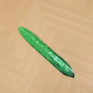 Green cucumber plush toy casing detail showing soft fabric texture and realistic print design.