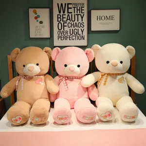 Large plush teddy bear detail showing soft fabric, cute heart embroidery, and plaid bow.