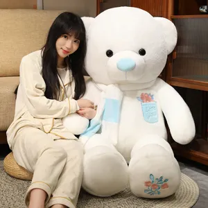Grande orsacchiotto di peluche bianco con naso blu, sciarpa e dettagli di ricamo di rose.