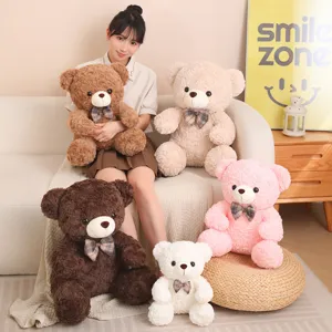 Detailed view of cute sitting plush teddy bear with plaid bow, soft stuffed doll in multi colors.