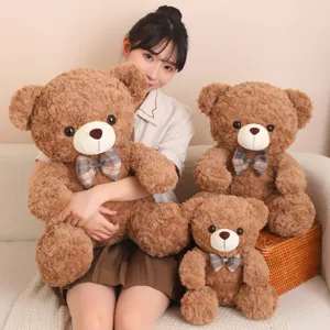 Cute sitting brown teddy bear plush toy with plaid bow tie soft stuffed doll gift companion for kids.