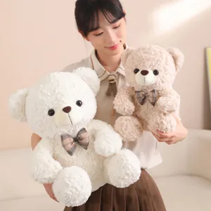 Cute teddy bear plush toy detail, soft stuffed animal with nice plaid bow tie.