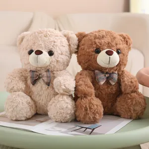 Cute sitting teddy bear plush toys detail view showing soft fabric texture and plaid bow tie design.