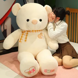 Giant plush teddy bear toy with heart embroidery and plaid bow, soft huggable stuffed animal for kids.
