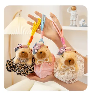 Vista dettagliata di simpatici ciondoli in peluche capibara con vestiti e cappelli.