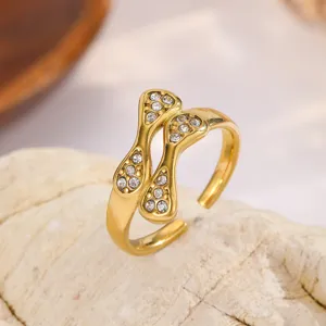 Squisito primo piano di un anello aperto dorato con pietre di zircone scintillanti.